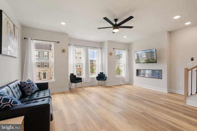 17303 Turnstone Dr, Dumfries, VA 22026 - living room with light wood finished floors, a ceiling fan, baseboards, recessed lighting, and a glass covered fireplace