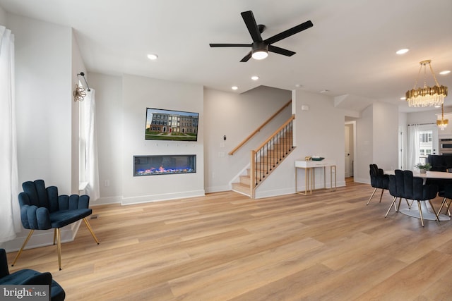 17303 Turnstone Dr, Dumfries, VA 22026 - living room with stairway, a glass covered fireplace, light wood-style flooring, recessed lighting, and ceiling fan
