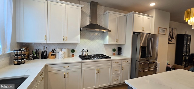 17303 Turnstone Dr, Dumfries, VA 22026 - kitchen featuring stainless steel appliances, wall chimney exhaust hood, white cabinetry, tasteful backsplash, and light stone countertops