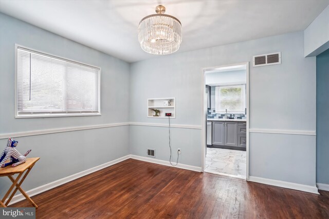6023 20th Ave, Hyattsville, MD 20782 - unfurnished dining area with wood finished floors, a chandelier, a sink, and baseboards