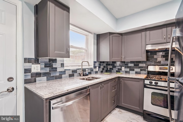 6023 20th Ave, Hyattsville, MD 20782 - kitchen featuring appliances with stainless steel finishes, gray cabinets, under cabinet range hood, a sink, and light marble finish flooring
