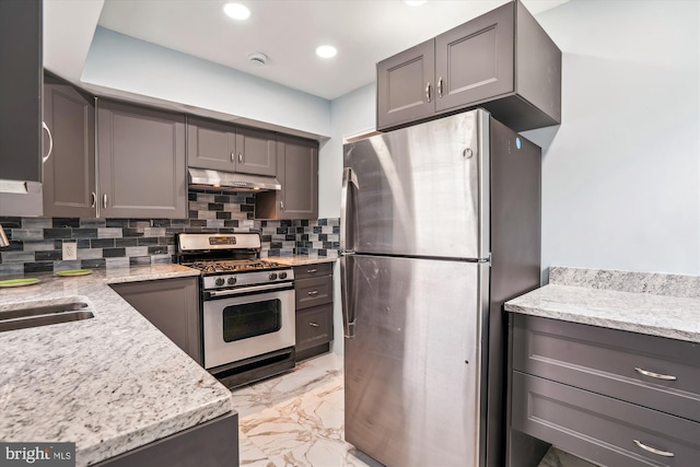 6023 20th Ave, Hyattsville, MD 20782 - kitchen with appliances with stainless steel finishes, under cabinet range hood, light marble finish floors, backsplash, and a sink