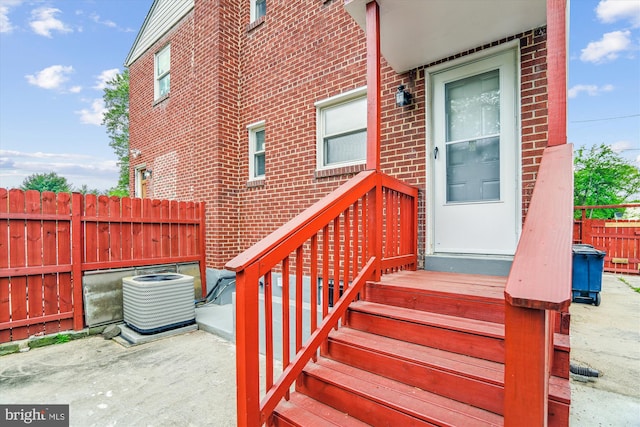 6023 20th Ave, Hyattsville, MD 20782 - property entrance with brick siding, central AC, fence, and a patio