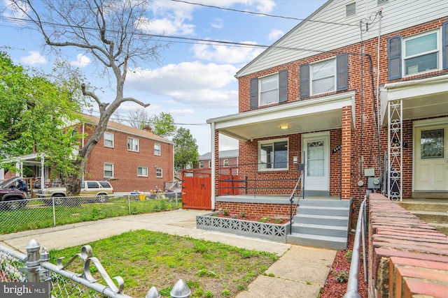 6023 20th Ave, Hyattsville, MD 20782 - view of front facade with brick siding, covered porch, and fence