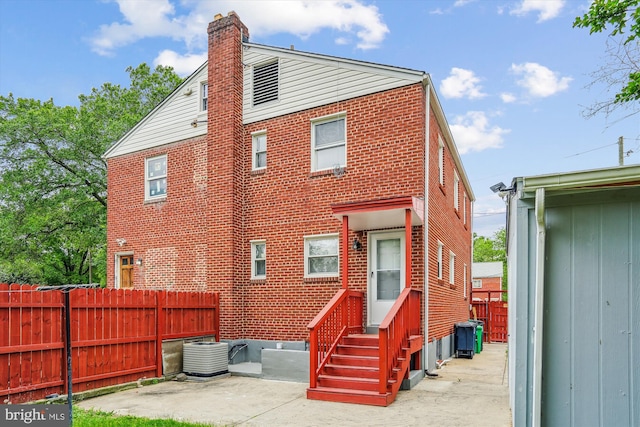 6023 20th Ave, Hyattsville, MD 20782 - back of property featuring entry steps, brick siding, a chimney, fence, and a patio area
