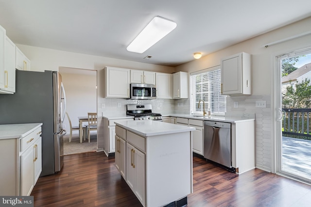kitchen featuring light countertops, a sink, appliances with stainless steel finishes, and plenty of natural light