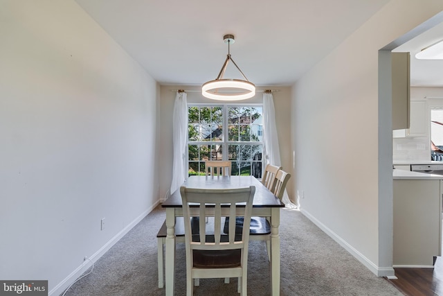 carpeted dining room with baseboards