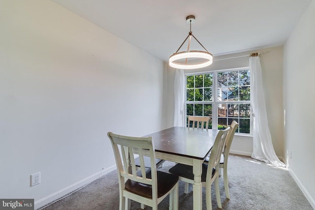 carpeted dining room with baseboards