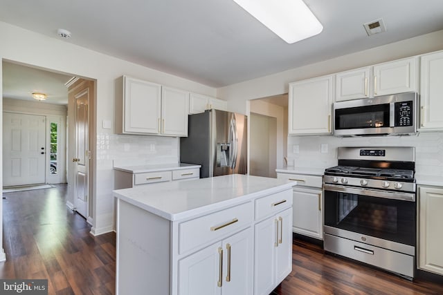 kitchen featuring stainless steel appliances, backsplash, visible vents, and dark wood finished floors
