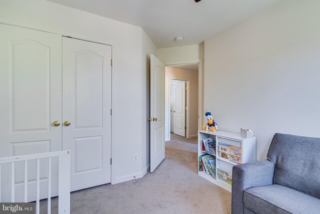 sitting room featuring light colored carpet and baseboards
