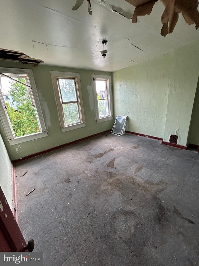 unfurnished room with baseboards