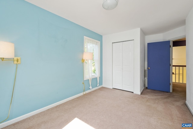 unfurnished bedroom with carpet floors, baseboards, and a closet