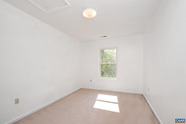unfurnished room featuring baseboards, light carpet, and visible vents