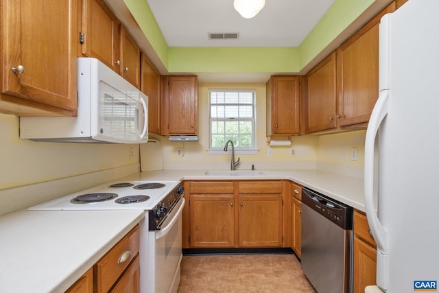 kitchen featuring a sink, light countertops, white appliances, and visible vents