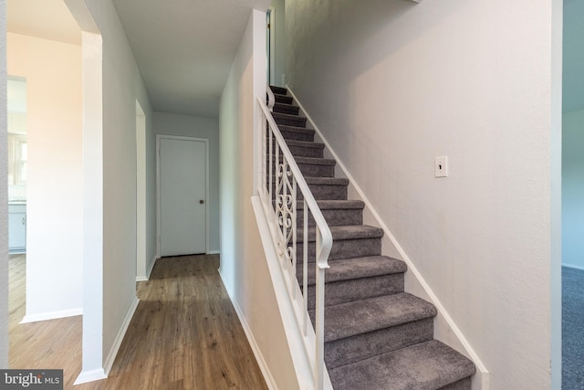 stairway with baseboards and wood finished floors