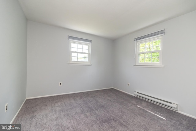carpeted spare room featuring baseboards and a baseboard heating unit