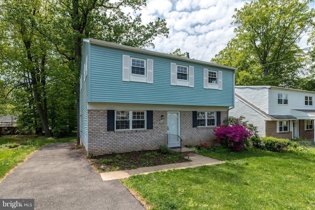 colonial house with brick siding and a front yard