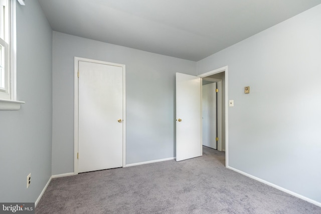 unfurnished bedroom with carpet floors and baseboards
