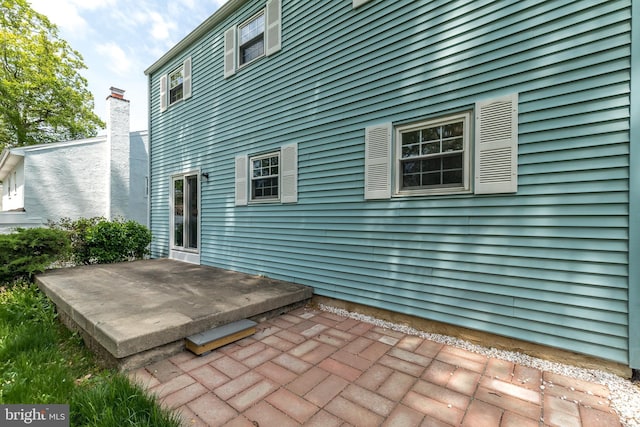 rear view of property with a patio and a chimney