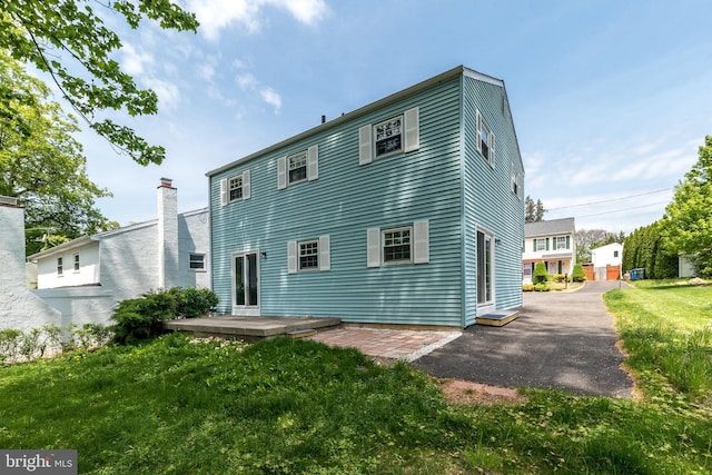 back of house with a patio and a yard