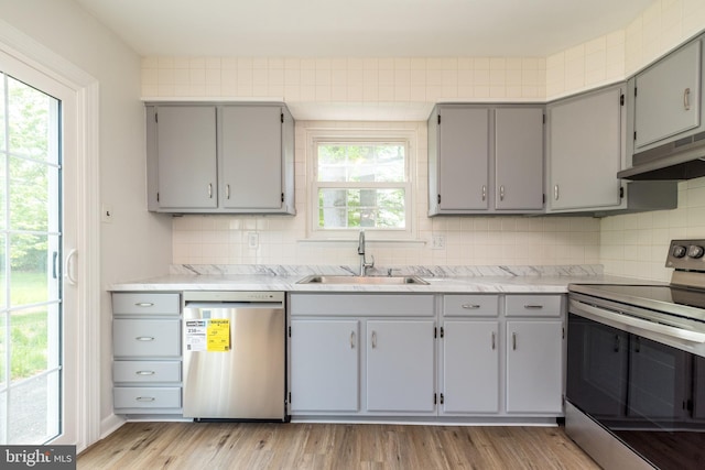 kitchen with gray cabinets, appliances with stainless steel finishes, and a sink