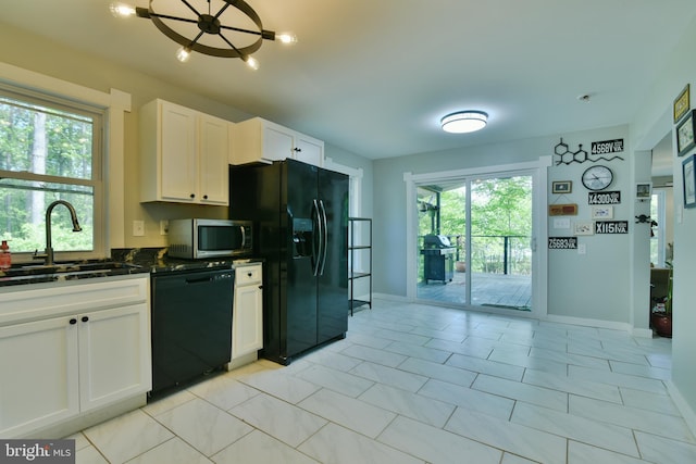 kitchen featuring black appliances, a sink, baseboards, and white cabinets
