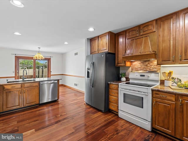 12553 Fawn Dr, Laurel, DE 19956 - kitchen with stainless steel appliances, custom exhaust hood, a sink, brown cabinetry, and recessed lighting