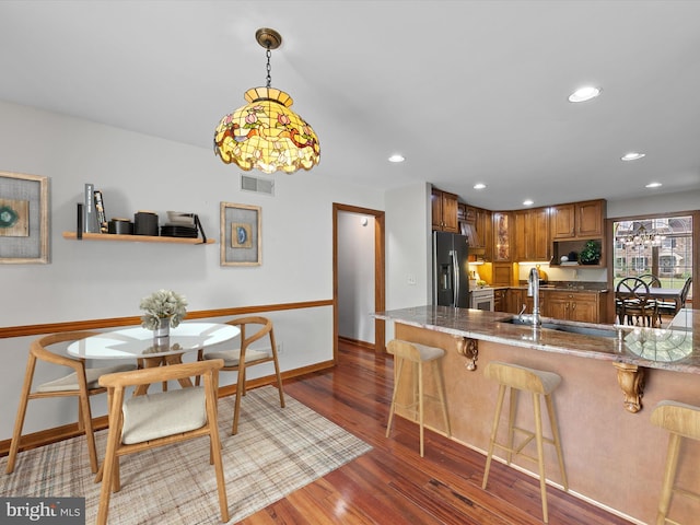 12553 Fawn Dr, Laurel, DE 19956 - kitchen featuring stainless steel appliances, a sink, a kitchen bar, wood finished floors, and recessed lighting