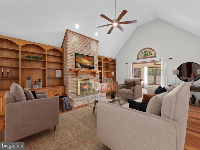 12553 Fawn Dr, Laurel, DE 19956 - living room featuring wood finished floors, ceiling fan, a fireplace, high vaulted ceiling, and built in shelves