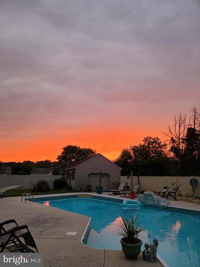12553 Fawn Dr, Laurel, DE 19956 - pool at dusk with a fenced backyard, a patio, and an outdoor structure