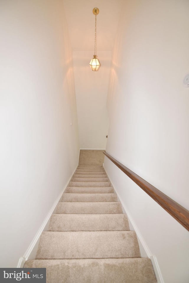 staircase with baseboards and carpet flooring