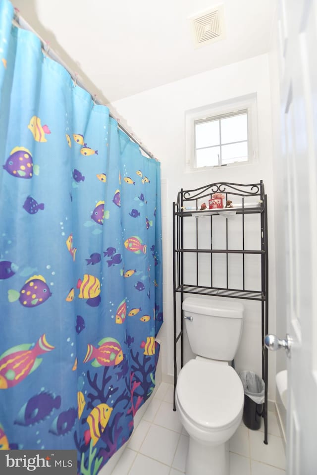 bathroom with tile patterned flooring, toilet, curtained shower, and visible vents