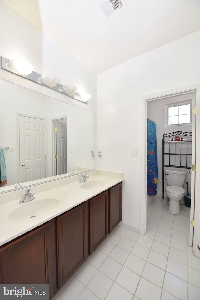 bathroom with double vanity, visible vents, a sink, and tile patterned flooring