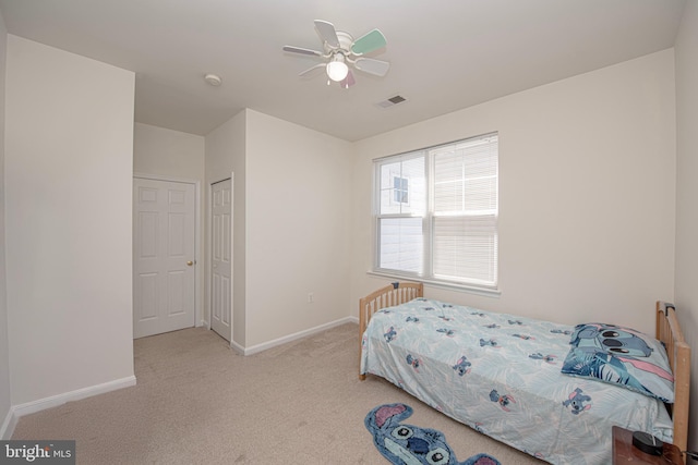 carpeted bedroom featuring baseboards, ceiling fan, a closet, and visible vents