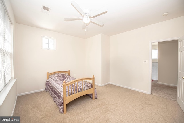 carpeted bedroom with baseboards, multiple windows, ceiling fan, and visible vents