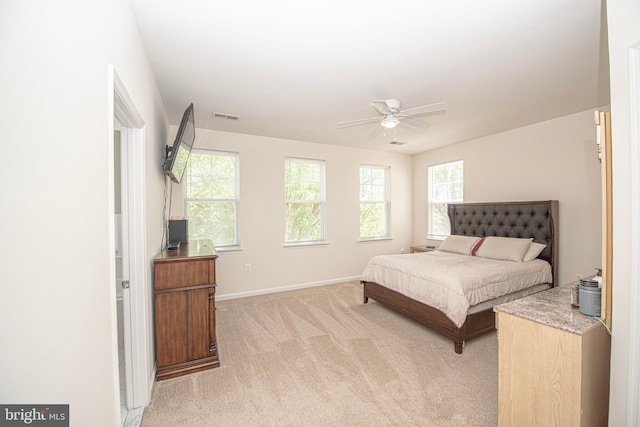 bedroom featuring baseboards, visible vents, light carpet, and ceiling fan