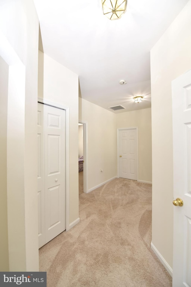 corridor with visible vents, carpet flooring, and baseboards