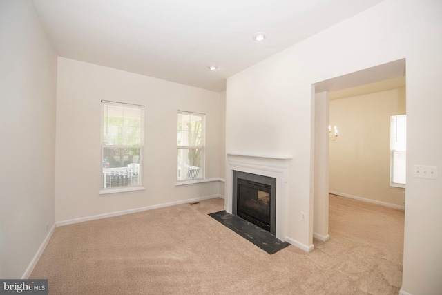 unfurnished living room with baseboards, carpet flooring, and a fireplace with flush hearth
