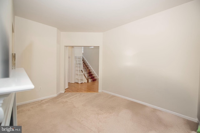 carpeted empty room featuring baseboards