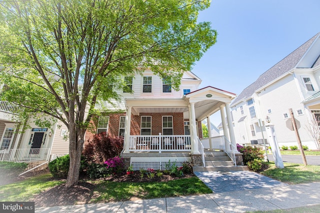 view of front of house with a porch and brick siding