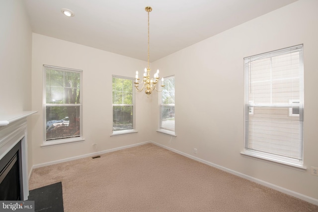 interior space with carpet flooring, baseboards, a chandelier, and a fireplace with flush hearth