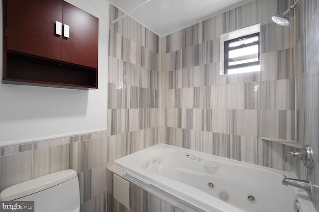 full bath with toilet and tile walls