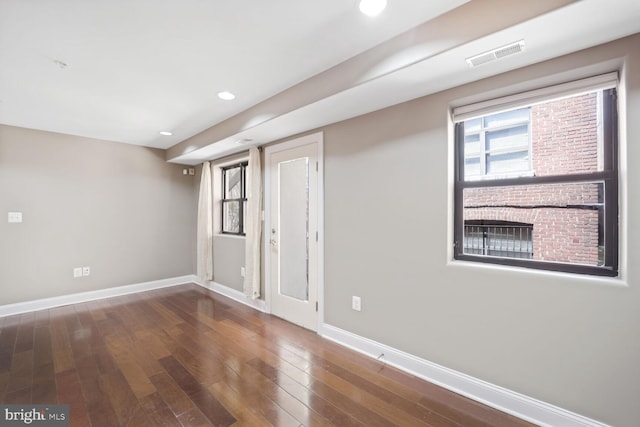 interior space with baseboards, recessed lighting, wood finished floors, and visible vents