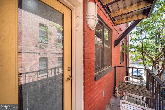 entrance to property featuring brick siding