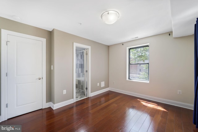 unfurnished room with baseboards, visible vents, and hardwood / wood-style floors