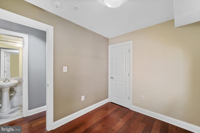 unfurnished bedroom featuring baseboards and dark wood finished floors
