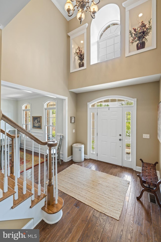 entrance foyer featuring a high ceiling, a chandelier, and baseboards