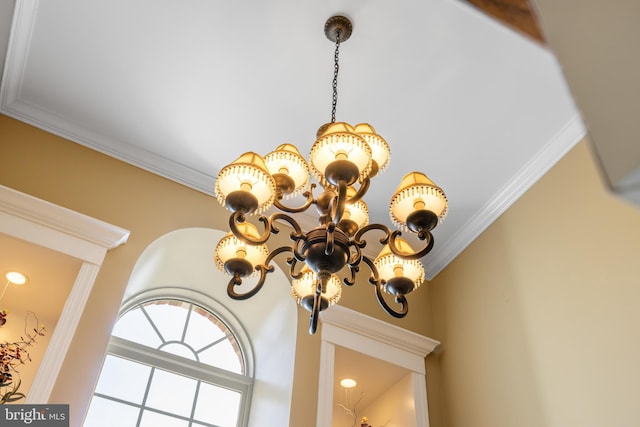details with ornamental molding and a chandelier