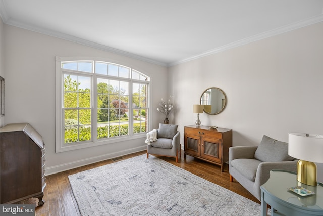 sitting room with crown molding, baseboards, visible vents, and a wealth of natural light