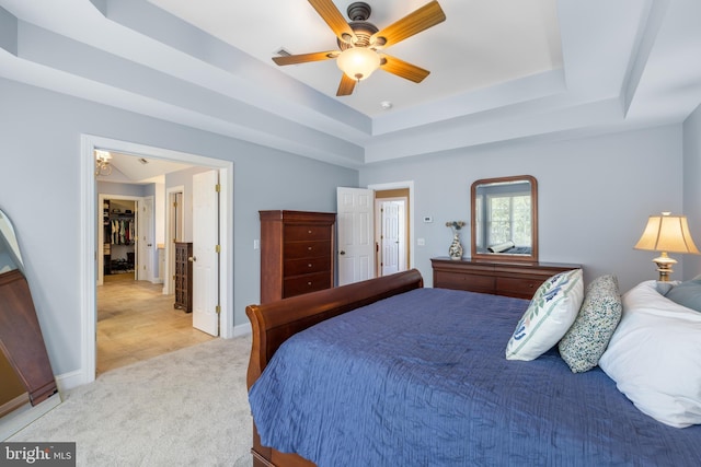 bedroom with visible vents, baseboards, ceiling fan, light colored carpet, and a raised ceiling